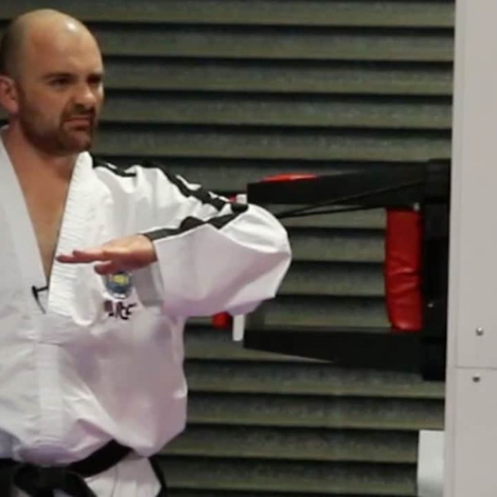 Taekwon-Do students practising breaking techniques under instructor guidance