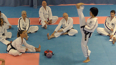 Veteran Taekwon-Do practitioners training flexibility during a Vets Seminar led by Master Joliette Trân
