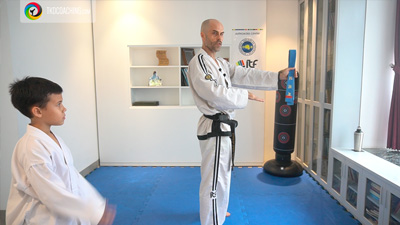 Master Mariusz emonstrating techniques during a kids class while a junior student follows along.